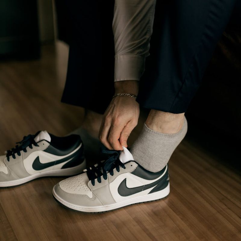 Close-up of athletic shoes on a wooden floor, suggesting movement and readiness.